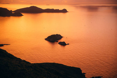 Scenic view of rocks in sea against sky during sunset