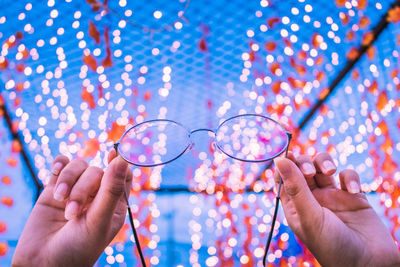 Close-up of human hand holding eyeglasses