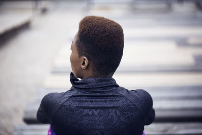 Rear view of sporty woman sitting at stadium