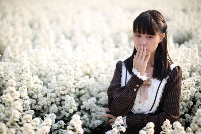 Young woman standing amidst flowering plants