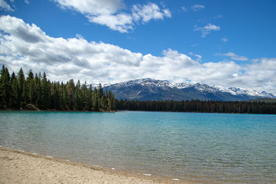 Scenic view of lake and mountains against blue sky