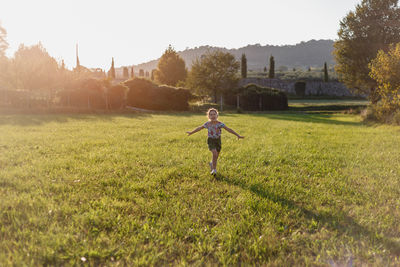 Rear view of woman walking on field