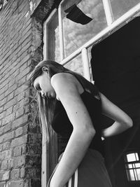 Low angle view of woman standing against window