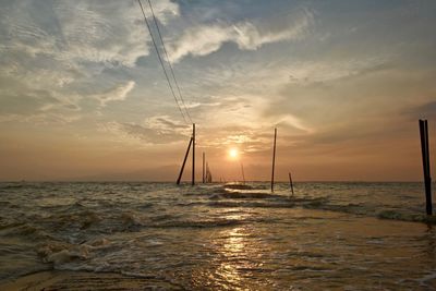 Sailboat on sea against sky during sunset