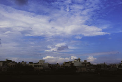 Buildings in city against cloudy sky