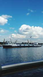 Cranes at harbor against blue sky