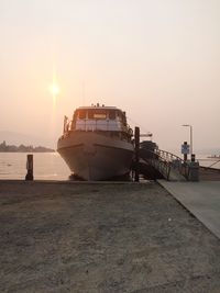 Boat moored at harbor against clear sky