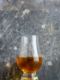 Close-up of beer glass on table against wall