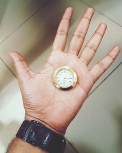 Close-up of hand holding clock