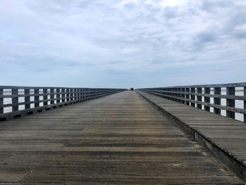 Footbridge over pier against sky