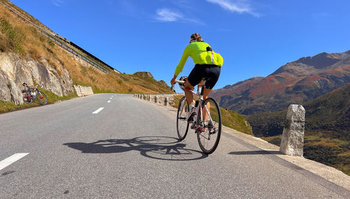 Rear view of man riding bicycle on mountain