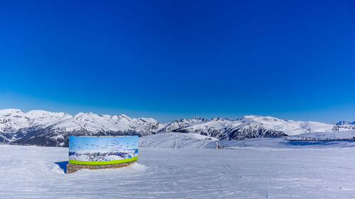 Scenic view of snowcapped mountains against blue sky