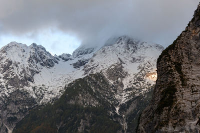 Scenic view of majestic rocky snow capped mountain peaks under grey clouds