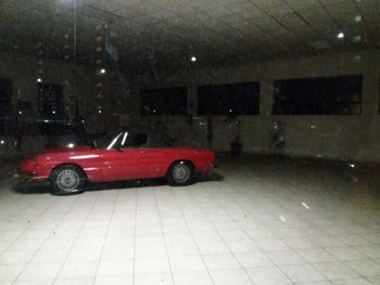 Red toy car on illuminated street in city during winter