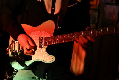 Midsection of man playing guitar