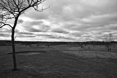 Scenic view of field against cloudy sky