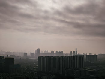 Cityscape against cloudy sky