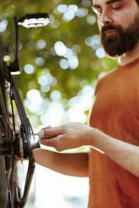 Midsection of man holding bicycle