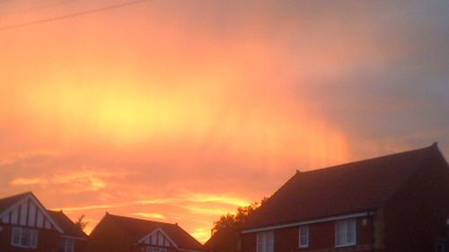 Low angle view of house against sky at sunset