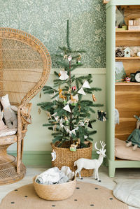 Stylish scandinavian christmas tree with toys and flags in the interior decor of the children's room