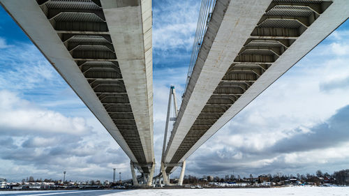 Low angle view of bridge against cloudy sky