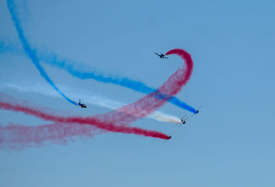 Low angle view of airplane flying against blue sky