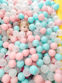 High angle view portrait of cute girl lying in ball of pool