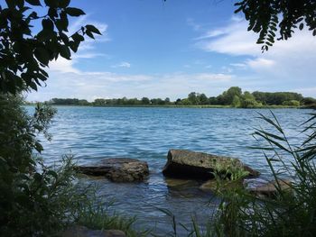 Scenic view of lake against cloudy sky