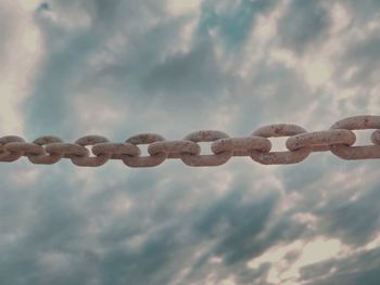 Close-up of chain against cloudy sky