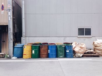 Abandoned containers on sidewalk against building