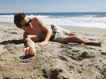Young couple on beach against sky