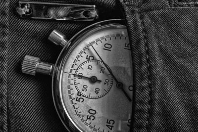 Close-up of clock in jeans pocket