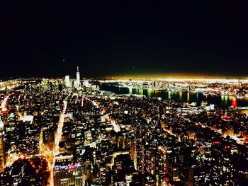 Illuminated cityscape against sky at night