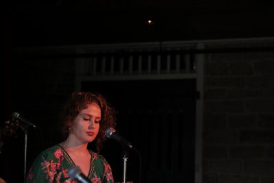 Woman singing on microphone at music concert