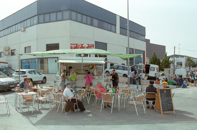 People in restaurant against buildings in city