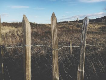 Wooden fence on field against sky