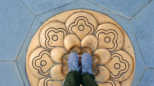 Low section of man standing on tiled floor