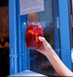Close-up of hand holding glass of juice