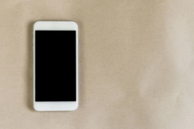 Close-up of mobile phone on brown paper