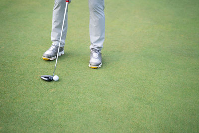 Low section of person standing on golf course