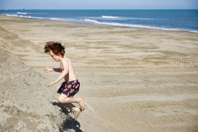 Rear view of boy on beach