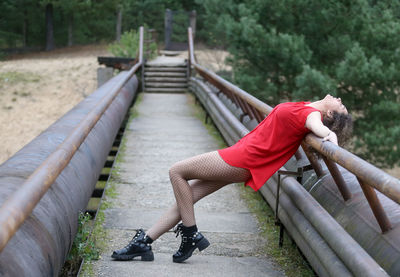 Full length of woman relaxing on footbridge