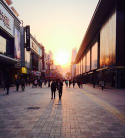 People walking in city at sunset
