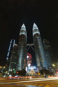 Illuminated modern buildings against sky at night