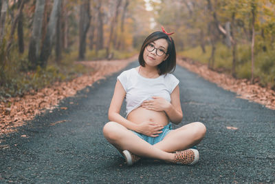Young expecting mom sitting on the floor with a cute expression