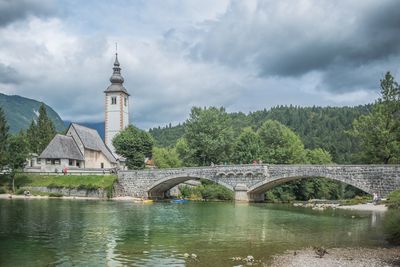 Bridge over river against cloudy sky