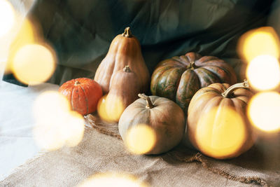 Large variety of pumpkins and bokeh from lanterns.