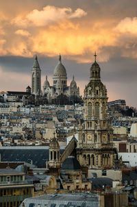 Buildings in city against sky during sunset