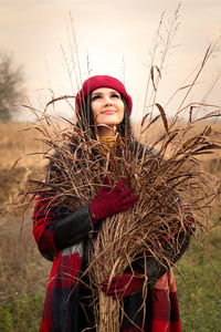 Woman holding dried out weed in a rural area