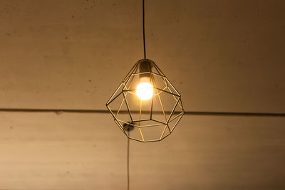 Low angle view of illuminated pendant light hanging from ceiling